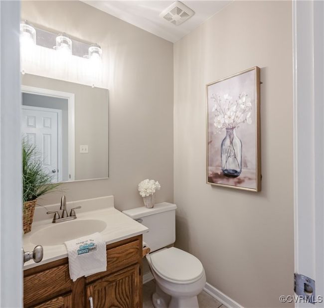 Bathroom with baseboards, visible vents, vanity, and toilet | Image 12