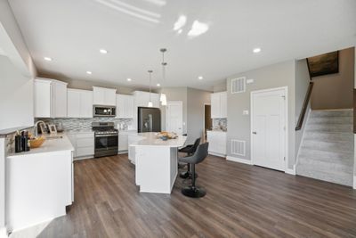 (Photo of model home, finishes will vary) This spacious kitchen features a large center island, quartz countertops, LVP floors, stainless appliances and more. | Image 3