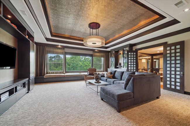 This refined second-level retreat seamlessly blends media lounge comfort with relaxation, featuring plush sculpted carpet and a spacious built-in window seat with hidden storage. Custom cabinetry flanks the game room and enhances both style and function, while the elevated floorplan offers a subtle sense of separation—perfect for a cozy, theater-like atmosphere. A conveniently connected full bathroom adds to the space’s effortless livability. | Image 36