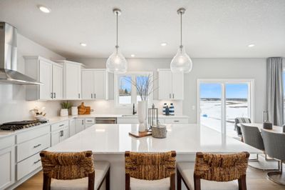 (Photo of model home, finishes will vary) Welcome to the Itasca! This spacious kitchen includes a large center island, quartz countertops, recessed lighting, LVP wood floors, stainless appliances and more. | Image 2