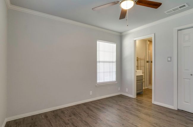 Empty room featuring a ceiling fan, dark wood finished floors, plenty of natural light, and crown molding | Image 23