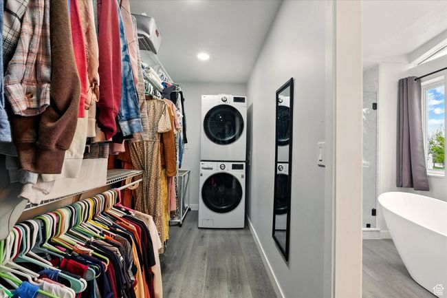Laundry area with stacked washer / drying machine, wood finished floors, and recessed lighting | Image 20