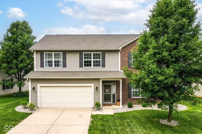 traditional home with driveway, a front yard, a garage, roof with shingles, and brick siding | Image 30