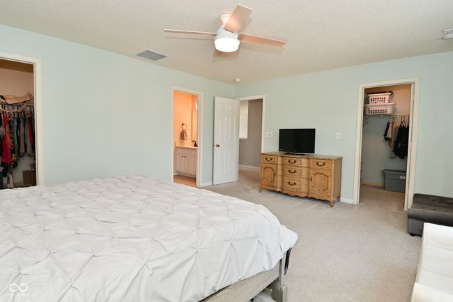 bedroom with a spacious closet, a closet, and light carpet | Image 38