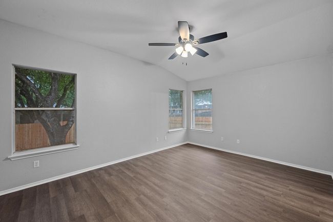 Bedroom with new flooring, ceiling fan, and vaulted ceiling | Image 16
