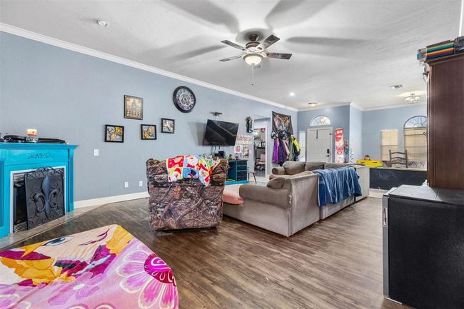 Living room featuring crown molding, ceiling fan, and dark hardwood / wood-style flooring | Image 6
