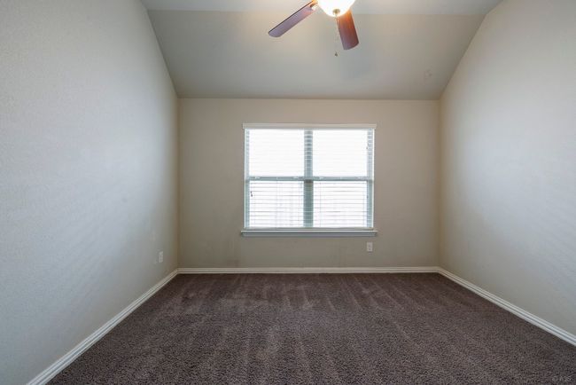 Spare room featuring lofted ceiling, ceiling fan, and dark colored carpet | Image 24