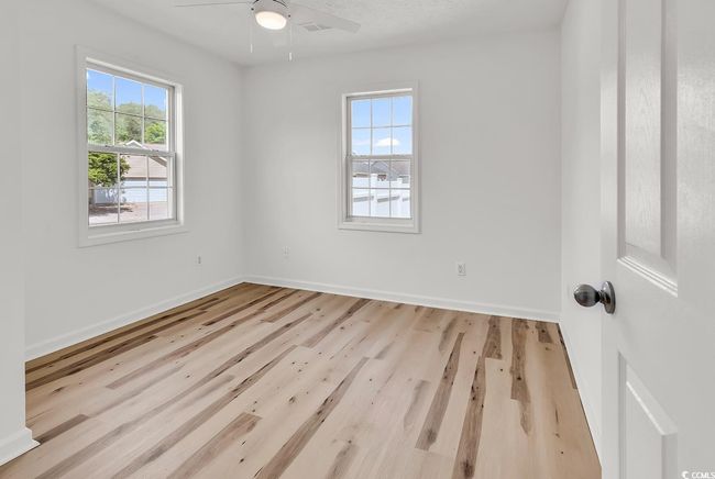 Spare room with baseboards, ceiling fan, and wood finished floors | Image 9