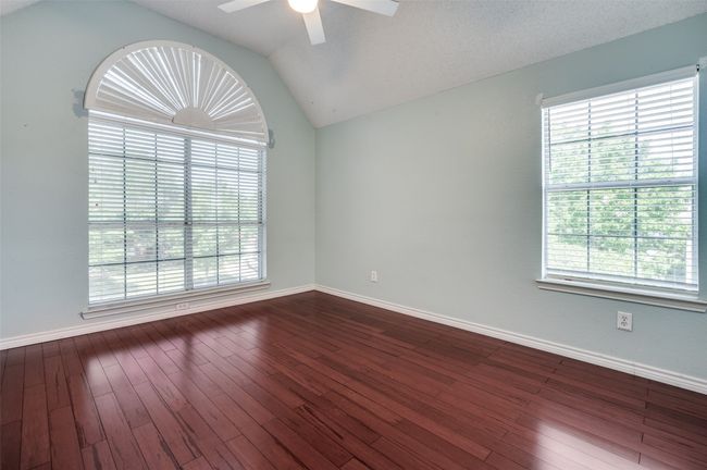 Spare room featuring dark wood finished floors, ceiling fan, lofted ceiling, and baseboards | Image 22