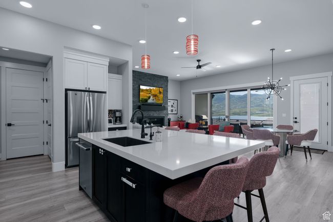Kitchen with a sink, appliances with stainless steel finishes, recessed lighting, light wood-style flooring, and light countertops | Image 17