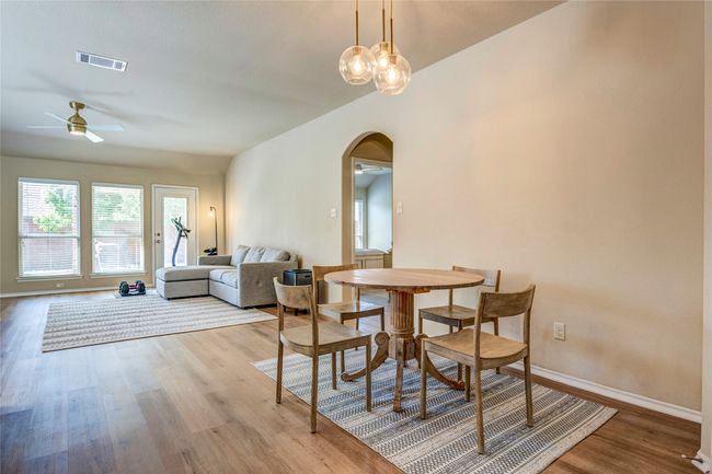 Dining area featuring visible vents, baseboards, arched walkways, ceiling fan, and light wood-style floors | Image 17
