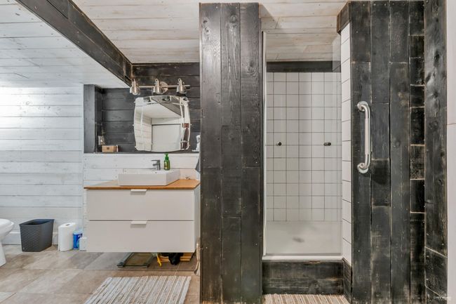 Full bathroom with wood walls, toilet, vanity, wood ceiling, and a stall shower | Image 29
