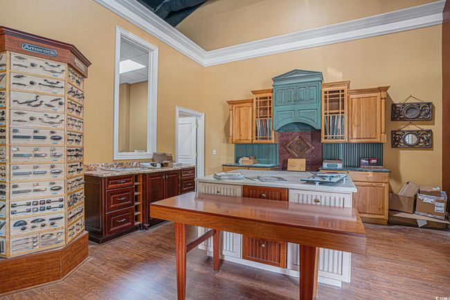 Front room with a high ceiling, dark wood-style floors, and light stone counters | Image 7