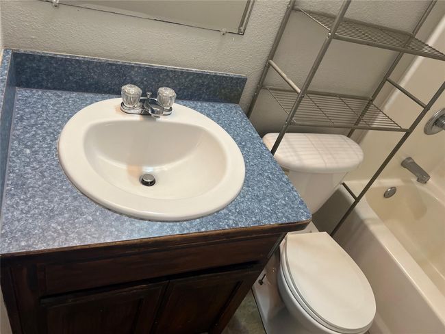 Full bath featuring vanity, shower / bath combination, and a textured wall | Image 21