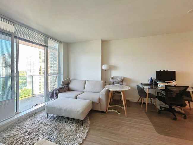 Living area with light wood finished floors, an office area, and baseboards | Image 4