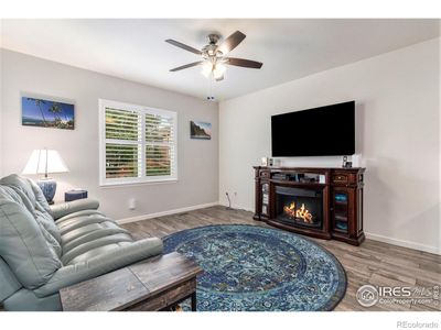 Living room with upgraded tile flooring and window shutters. | Image 3