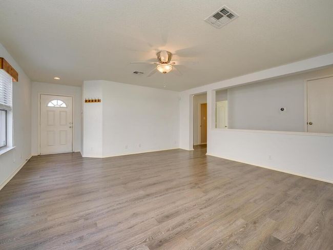 Living room with luxury vinyl wood look flooring and a ceiling fan. | Image 7