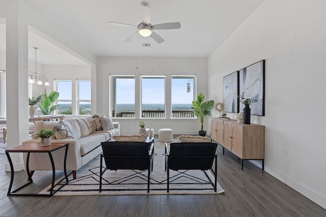 The back wall of the home is adorned with oversized windows that maximize the hill country views and bathe the living space in peaceful natural light. | Image 11