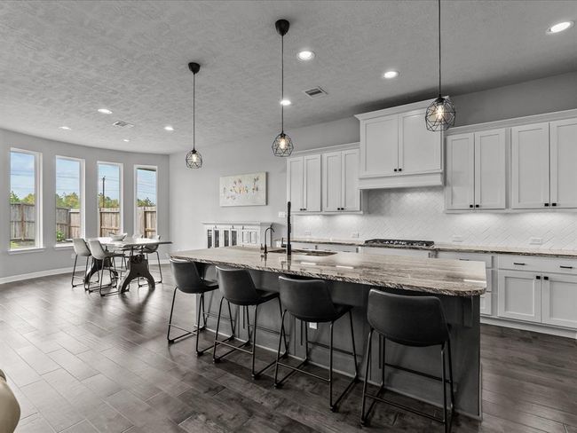 Chef's eat-in island kitchen features 42" cabinets with crown molding, under cabinet lighting, designer backsplash, stainless steel appliances and legthy countertops | Image 9