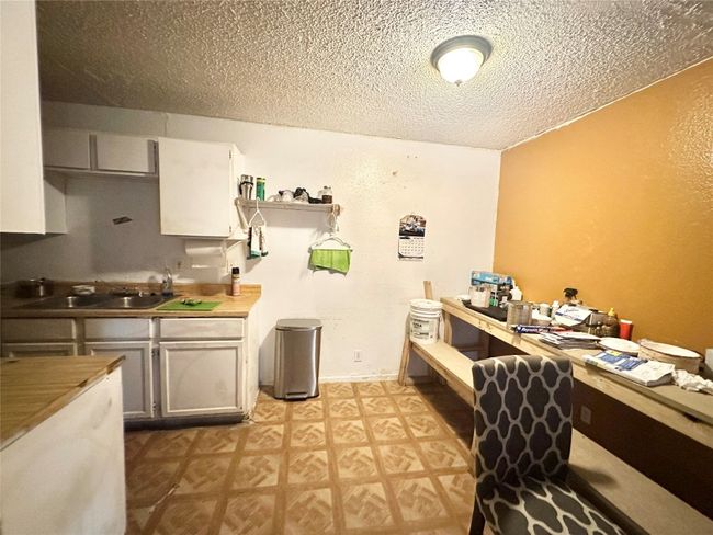 Kitchen with a sink, open shelves, a textured ceiling, light countertops, and light floors | Image 33