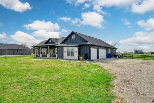 View of front facade featuring a garage, covered porch, and a front lawn | Image 4