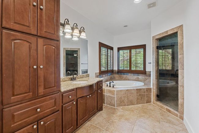 Bathroom with a garden tub, vanity, a stall shower, and tile patterned flooring | Image 32