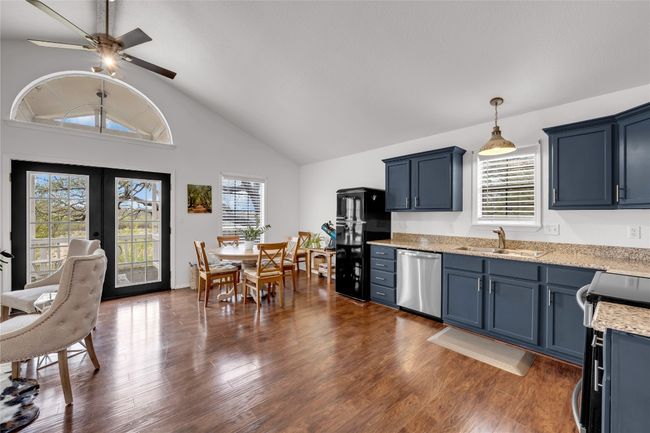 Kitchen featuring dark wood-type flooring, range with electric convection stovetop, a sink, and dishwasher | Image 14