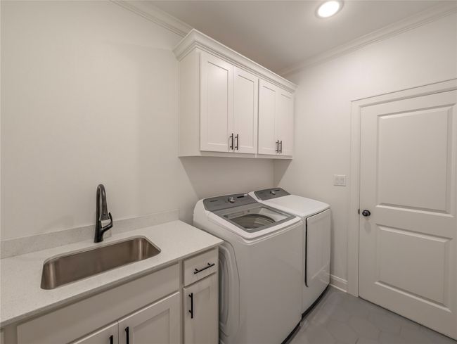 Laundry area featuring cabinet space, washer and dryer, crown molding, light tile patterned flooring, and recessed lighting | Image 34