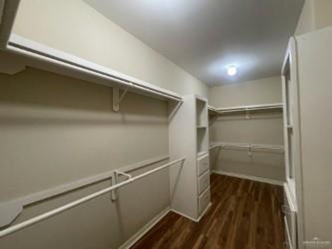 Walk in closet featuring dark wood finished floors | Image 6