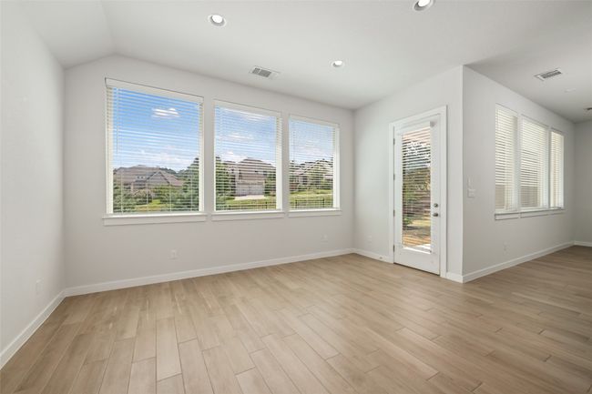 Dining room area featuring light wood tile floors, recessed lighting, and a vaulted ceiling | Image 13