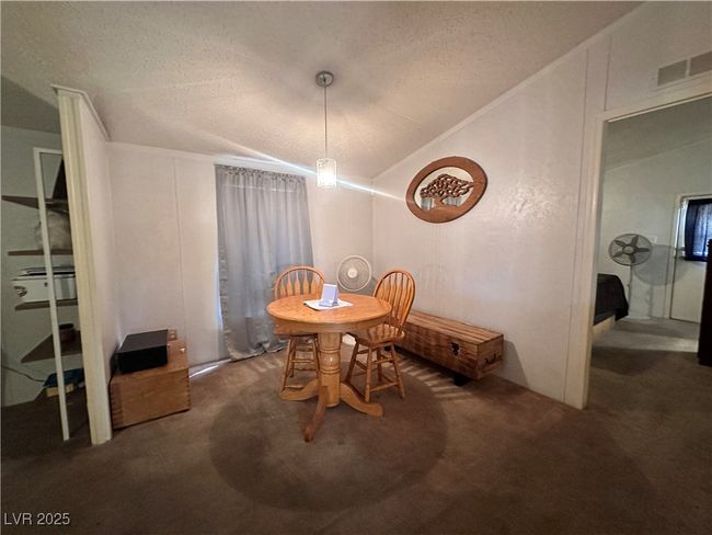 Dining space with lofted ceiling, a textured ceiling, visible vents, and carpet floors | Image 19