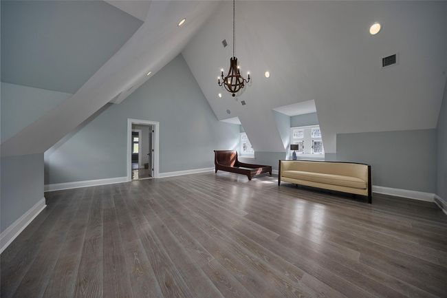 Additional living space featuring an inviting chandelier, visible vents, dark wood-style flooring, and baseboards | Image 22