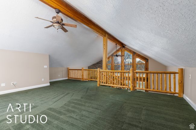 Additional living space featuring baseboards, lofted ceiling with beams, a textured ceiling, carpet floors, and ceiling fan | Image 37