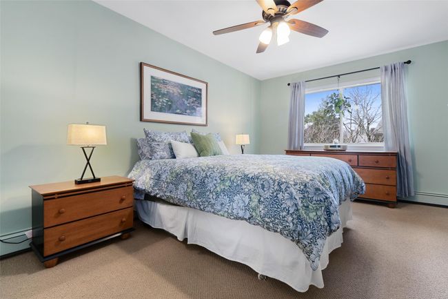 Primary bedroom with ceiling fan leads to a an ensuite bathroom with shower/tub | Image 11