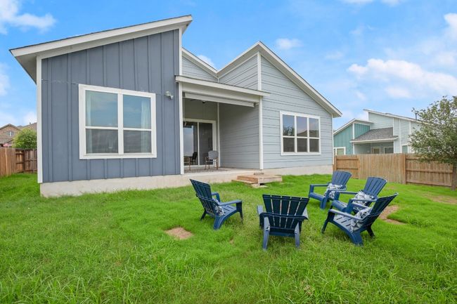 Rear view of house featuring board and batten siding, a patio area, and a fire pit | Image 23