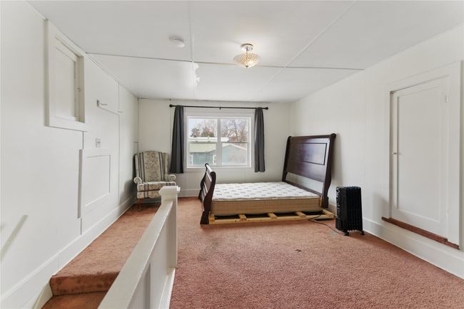 Carpeted bedroom featuring radiator heating unit and baseboards | Image 22
