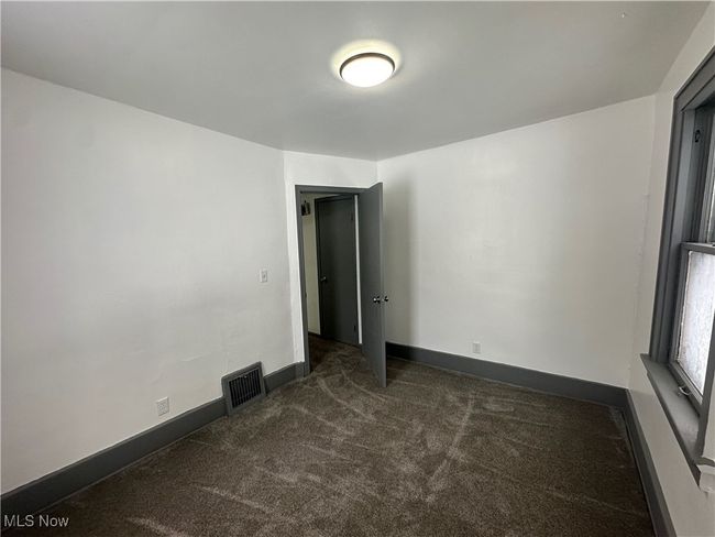 Carpeted empty room with visible vents and baseboards | Image 28
