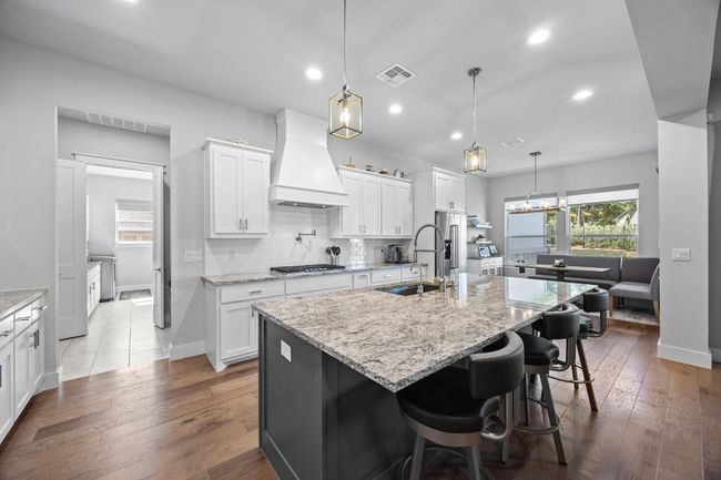 The gourmet kitchen is ideal for hosting gatherings and provides a delightful view of the living area. It boasts custom cabinetry equipped with soft-close features, high-end KitchenAid appliances, a gas cooktop with a pot filler, and a farmhouse sink complemented by a stylish designer faucet. There is also a sizable walk-in pantry. | Image 17