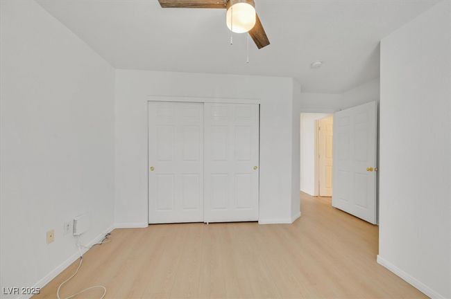 Unfurnished bedroom featuring wood finished floors, a closet, and a ceiling fan | Image 14