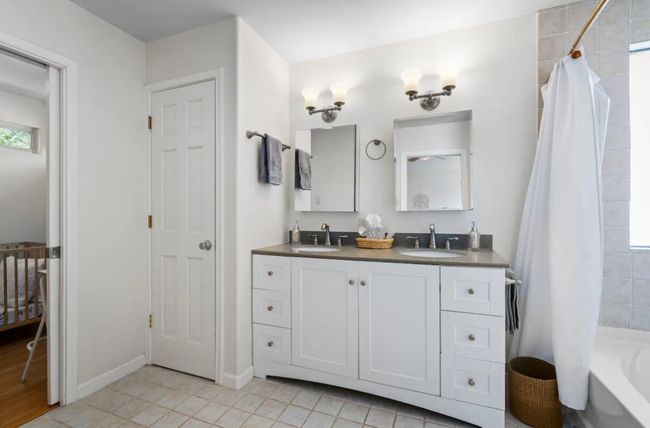 Bathroom featuring double vanity, shower / bath combo with shower curtain, and tile patterned flooring | Image 20