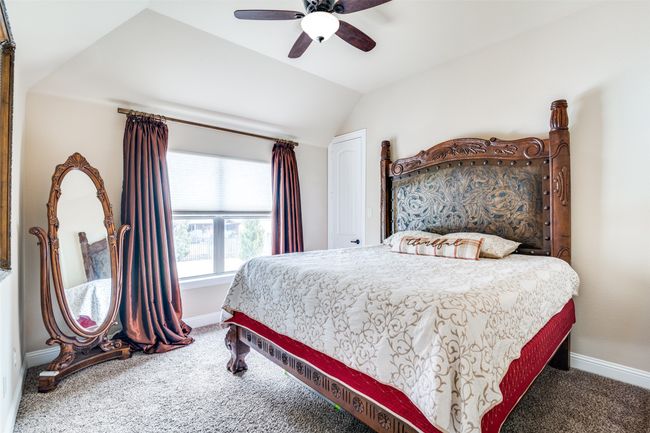 Bedroom featuring a vaulted ceiling, fan and walk-in closet. | Image 24