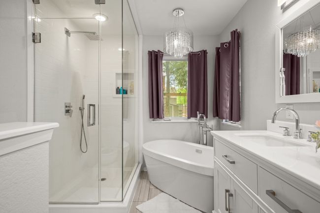With a dual vanity and a sleek, frameless glass shower, the ensuite bath combines both modern design and thoughtful details, creating a calming space for everyday indulgence | Image 19