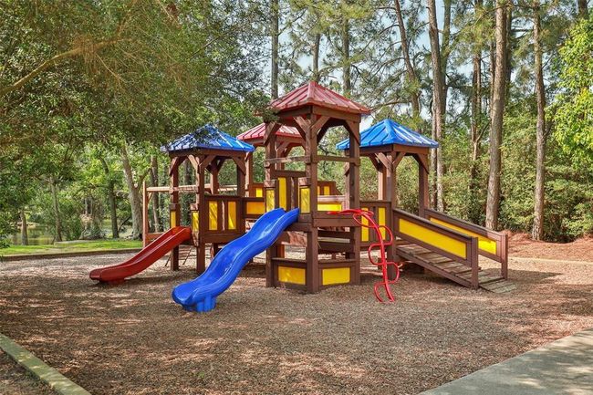 A colorful playground nestled among tall trees provides a safe and shaded outdoor space for children to play and explore. | Image 44