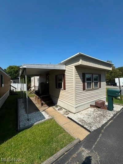 View of front of house featuring a front yard and a carport | Image 1