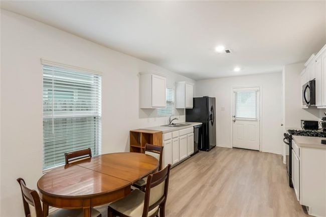 Bright and open dining area, ideal for gathering around the table for meals, homework, or game night. | Image 7