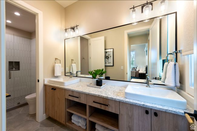 Ensuite bathroom featuring a stall shower, double vanity, tile patterned floors, and recessed lighting | Image 37