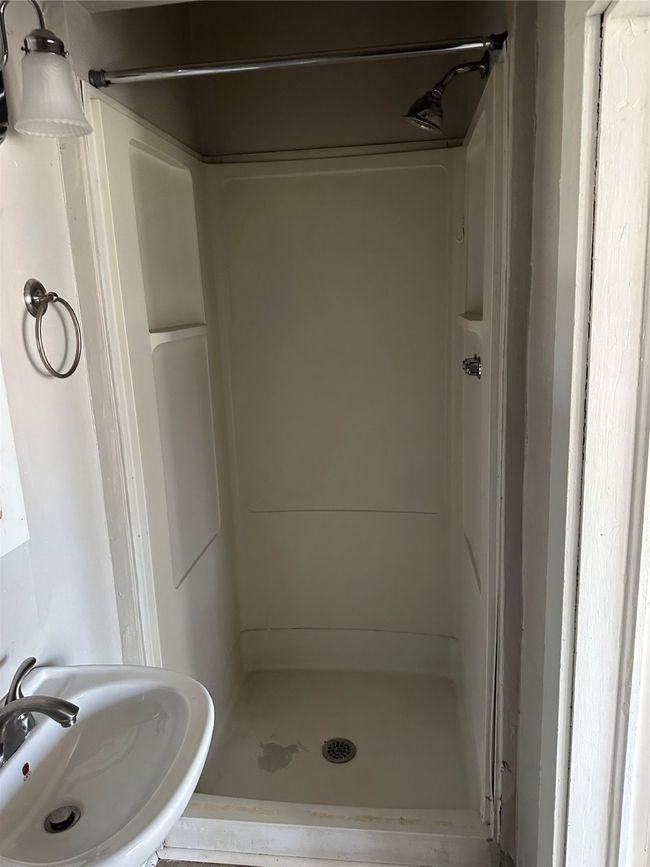 Bathroom featuring a shower stall and a sink | Image 7