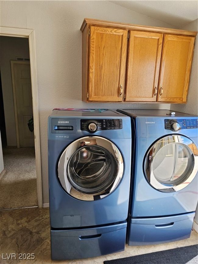 Laundry room with a textured wall, cabinet space, visible vents, and independent washer and dryer | Image 27