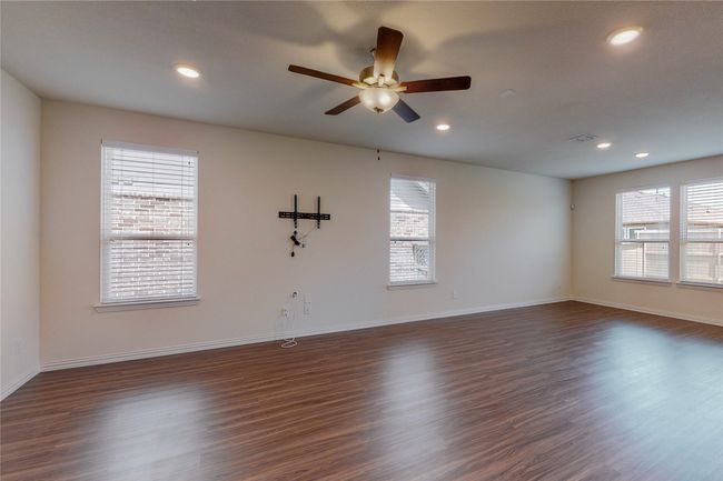 Spare room with healthy amount of natural light, ceiling fan, recessed lighting, dark wood-style flooring, and baseboards | Image 5