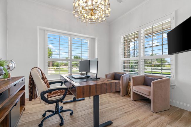 Home office featuring a chandelier, plenty of natural light, ornamental molding, light wood finished floors, and baseboards | Image 25